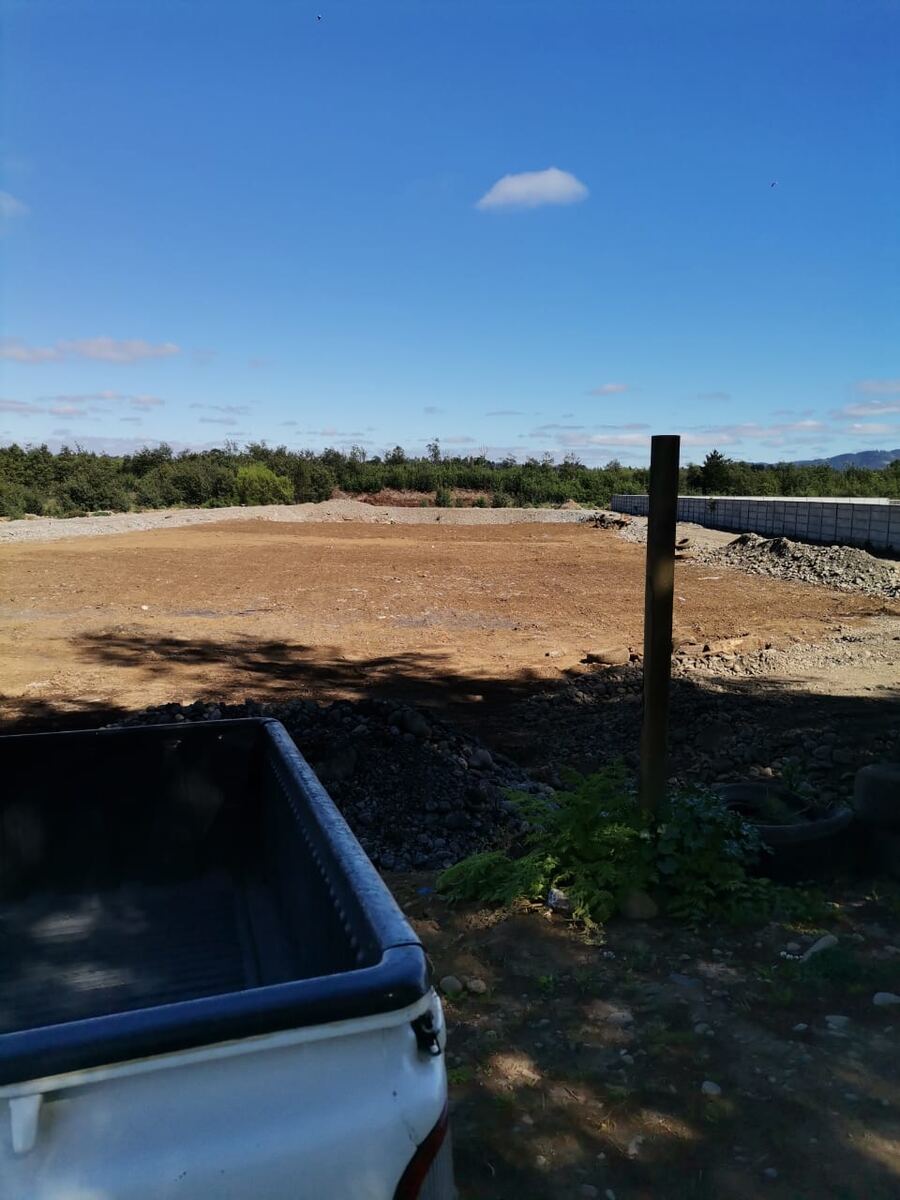 Foto real: terreno despejado y nivelado, con cierre perimetral de hormigón