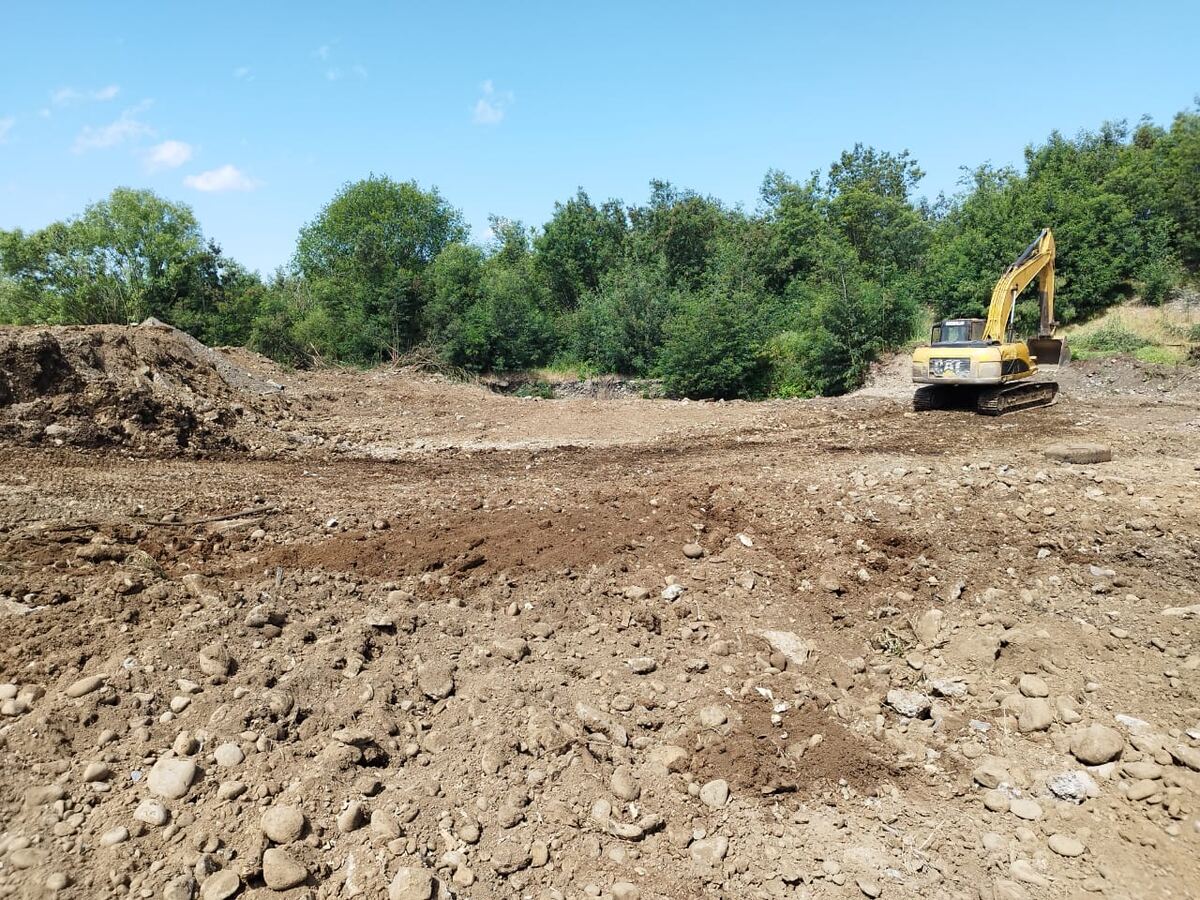 Foto real: excavadora trabajando en la nivelación del terreno